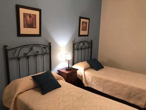 a bedroom with two beds and a lamp on a table at CASA RURAL LA IBIENZA in Zarzuela del Pinar