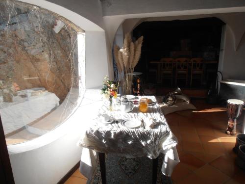 a dining room with a table and a large window at Casa Alianda in Telti
