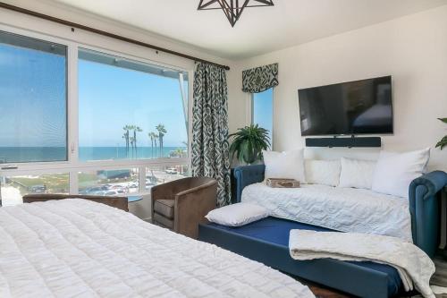 インペリアル・ビーチにあるOcean View 3 Bedrooms Condo, just steps from the park, pier & water!のベッドが2つと大きな窓がある寝室