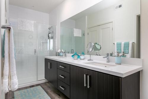 y baño con lavabo y ducha. en Ocean View 3 Bedrooms Condo, just steps from the park, pier & water! en Imperial Beach