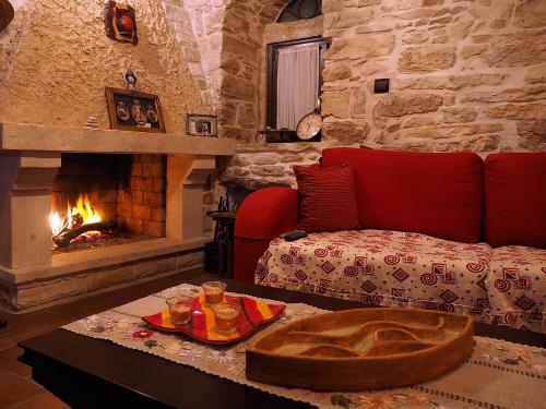 a living room with a couch and a fireplace at Traditional Tower in the center of kalamoti in Chios