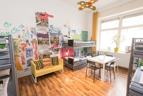 a room with a table and a wall with posters at Kiez Hostel Berlin in Berlin