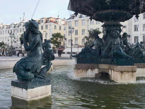 a fountain in a city with a statue in the water at Hotel ibis Lisboa Jose Malhoa in Lisbon