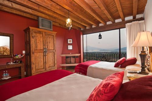 two beds in a room with red walls at Porton del Cielo in Pátzcuaro