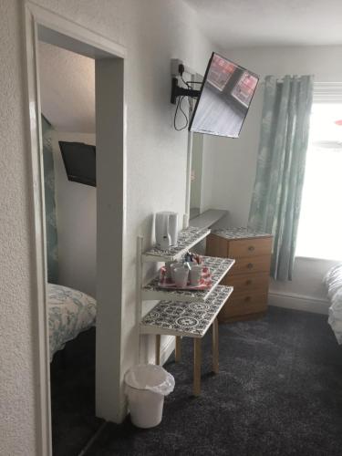Un dormitorio con espejo y una mesa con tazas. en Granville Hotel, en Blackpool