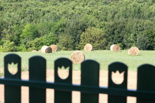 a fence with hay bales in a field at Pálos Resort in Zalacsány