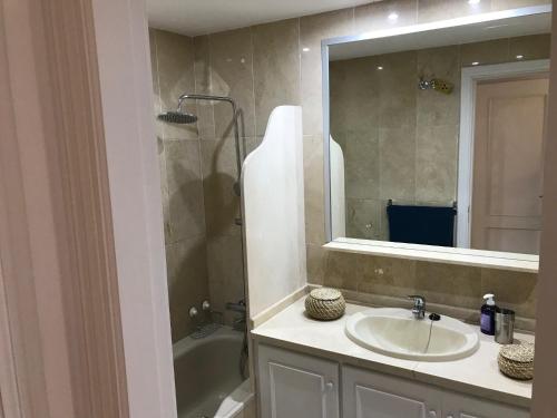 y baño con lavabo, ducha y espejo. en Marbella - Estepona beach frontline apartment, en Estepona