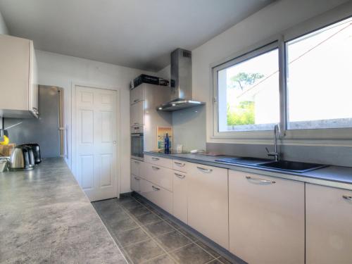 une cuisine avec des armoires blanches et une fenêtre dans l'établissement Holiday Home La Plage by Interhome, à Labenne