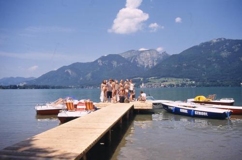 a group of people standing on a dock with boats at Hotel YOUHEY am Wolfgangsee in Strobl