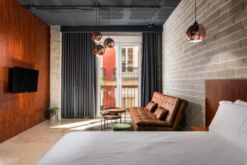 a bedroom with a bed and a couch and a chair at Alicante Aparthotel Evolution in Alicante