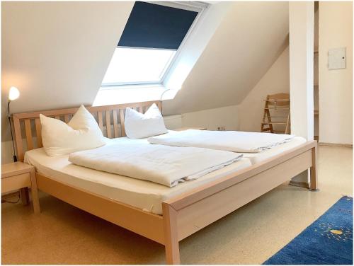 ノルダーナイにあるApartment mit Meerblickのベッドルーム1室(白いシーツ付きのベッド1台、窓付)
