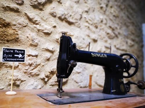 a black sewing machine on a table with a sign at Suite Inn Centro Dimora Storica in Enna