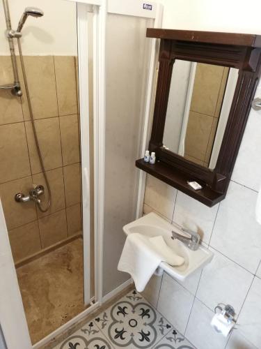 a bathroom with a sink and a shower with a mirror at Urkmez Hotel in Selcuk