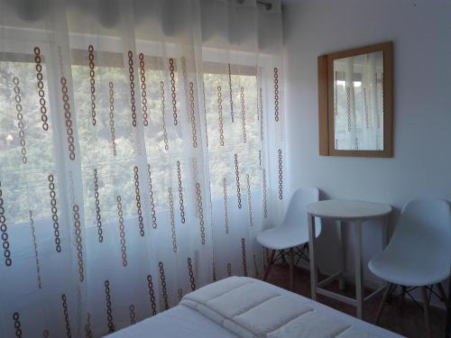 um quarto com uma cama, 2 cadeiras e uma janela em UN ESPACIO DONDE CREAR GRANDES RECUERDOS em Calella