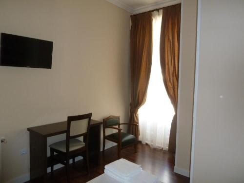 um quarto com uma mesa e cadeiras e uma janela em Hostal Mayor em Madri