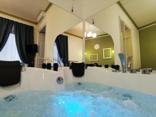 a jacuzzi tub in a bathroom with a mirror at Suite Inn Centro Dimora Storica in Enna