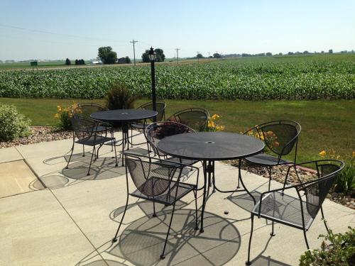 a group of tables and chairs in front of a field at AmericInn by Wyndham Osage in Osage