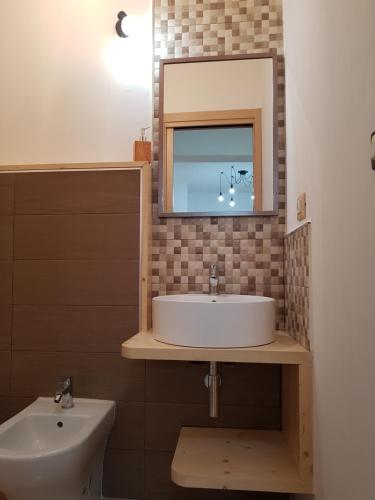 a bathroom with a sink and a tv on the wall at B&B Casa Alessandro in Scalea