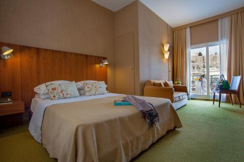雅典的住宿－菲利普斯酒店，酒店客房带一张大床和一把椅子