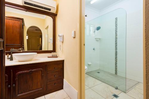 a bathroom with a shower, sink, and tub at Overlander Homestead Motel in Roma