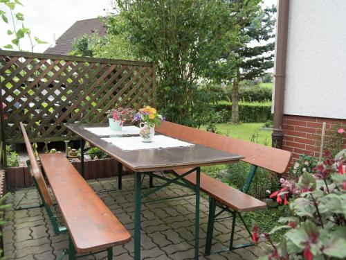 un tavolo con due panche e un tavolo con fiori di Cosy Apartment in Werda with Garden a Werda