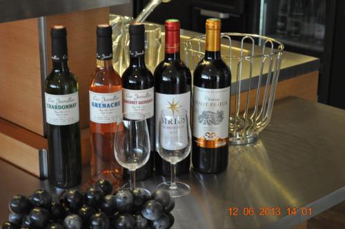 a group of wine bottles and glasses on a counter at ibis budget Istres Trigance in Istres