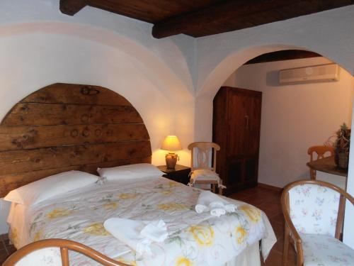 a bedroom with a large bed with a wooden headboard at Casa Alianda in Telti