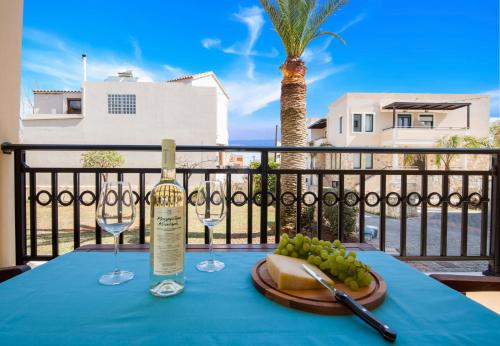 a table with a bottle of wine and wine glasses at Gianthea Studios and Apt in Stalos