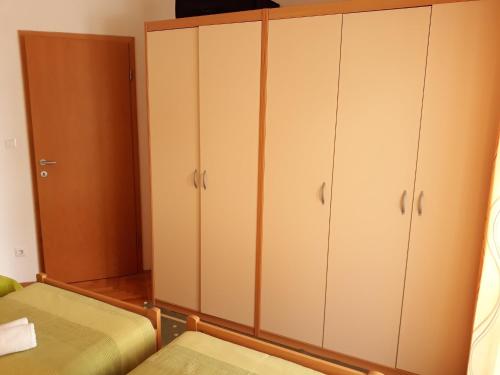 una camera con armadi bianchi e un letto di Apartment Zdravko - with parking a Omiš (Almissa)