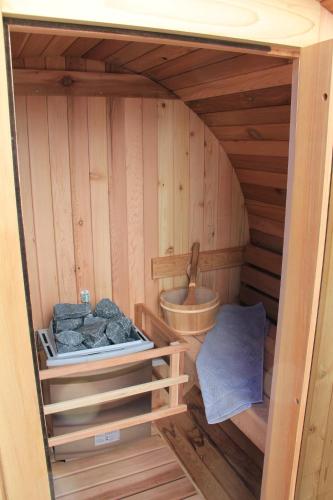 a small wooden sauna with a sink and rocks at Hotel het Rietershuijs in Kalenberg