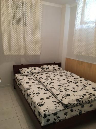 een slaapkamer met een bed met een zwart-wit dekbed bij Calista Luxury Appt in Polykhrono