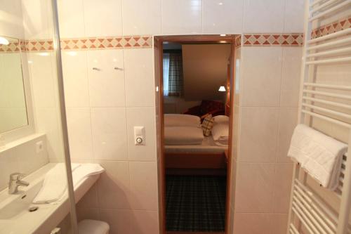 a bathroom with a shower and a sink and a mirror at Gasthof Karlwirt in Sankt Andrä im Lungau
