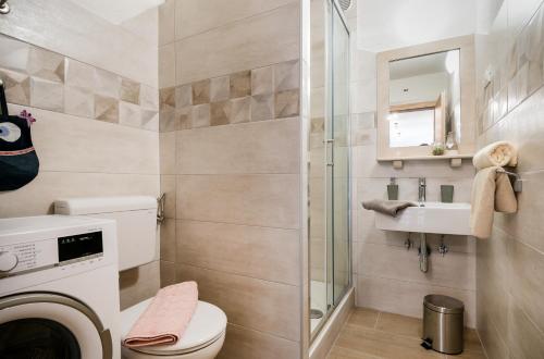 a bathroom with a toilet and a sink and a mirror at Apartment Cesarica in Baška Voda