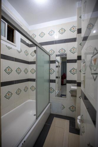 a bathroom with a shower and a bath tub at Sunnyside Hotel-Downtown San Francisco in San Francisco