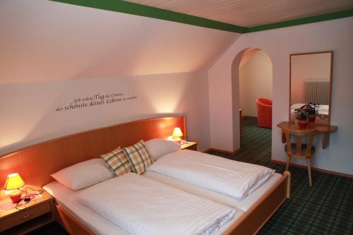 a bedroom with a bed with white sheets at Gasthof Karlwirt in Sankt Andrä im Lungau