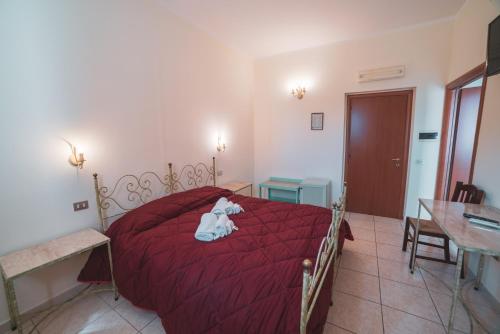 a bedroom with a red bed with a stuffed animal on it at Villa Alberta Hotel in Pula