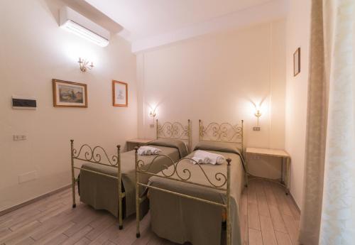 a group of four beds in a room at Villa Alberta Hotel in Pula