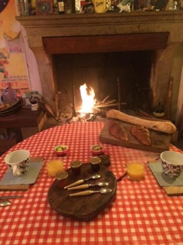 a table with a table cloth with a fire in a fireplace at La Cale de Barie in Barie