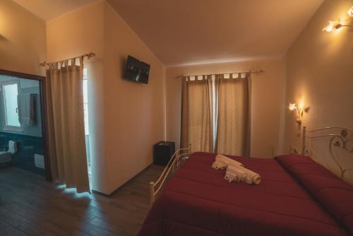 a bedroom with a bed with a red blanket at Villa Alberta Hotel in Pula