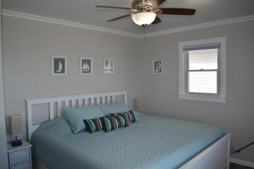 a bedroom with a bed with a ceiling fan at Stafford Lake House in McHenry