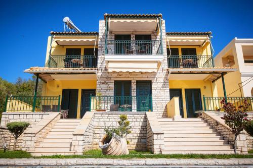 a yellow house with stairs in front of it at Koronisia Apartments in Koronisia