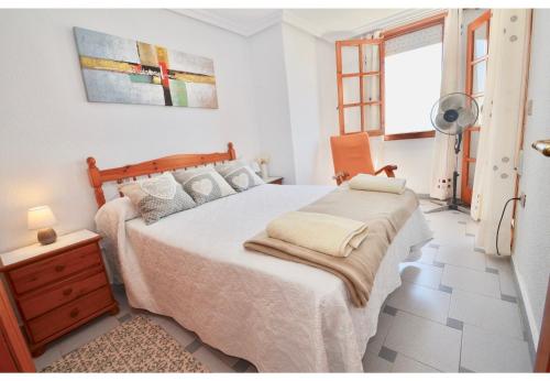ein Schlafzimmer mit einem Bett, einer Kommode und einem Fenster in der Unterkunft 12 Sunny Sea Views in La Mata