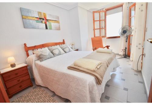 a bedroom with a bed and a dresser and a window at 12 Sunny Sea Views in La Mata