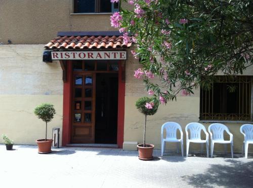 a group of white chairs in front of a building at Hotel Moderno in Aritzo