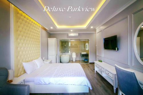 a bedroom with a white bed and a bathroom at La Galerie Hotel in Ho Chi Minh City
