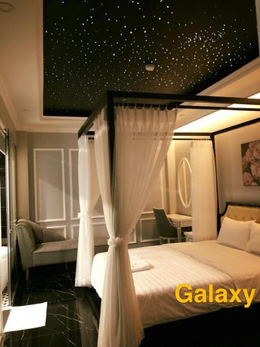 a bedroom with a bed with a canopy at La Galerie Hotel in Ho Chi Minh City