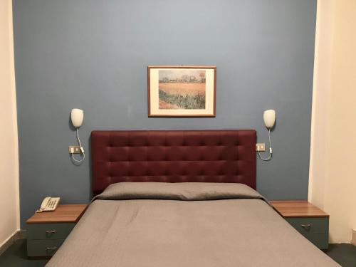 un letto con testiera rossa in una camera da letto di Hotel Sesto a Sesto San Giovanni