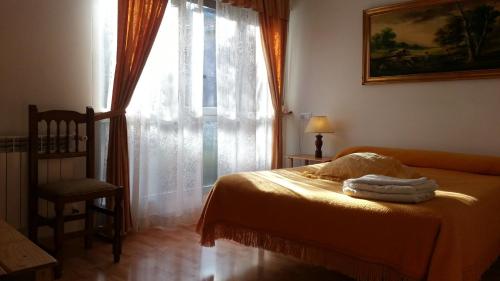 a bedroom with a bed and a window and a chair at Pension Paulina in Cue