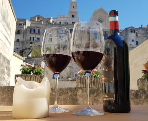 2 bicchieri di vino e una bottiglia di vino di Due forni affittacamere a Matera