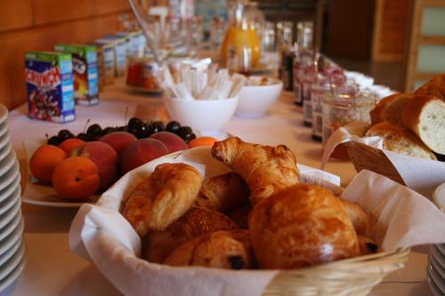 a table topped with a basket of pastries and fruit at Hôtel Valery in Montélier